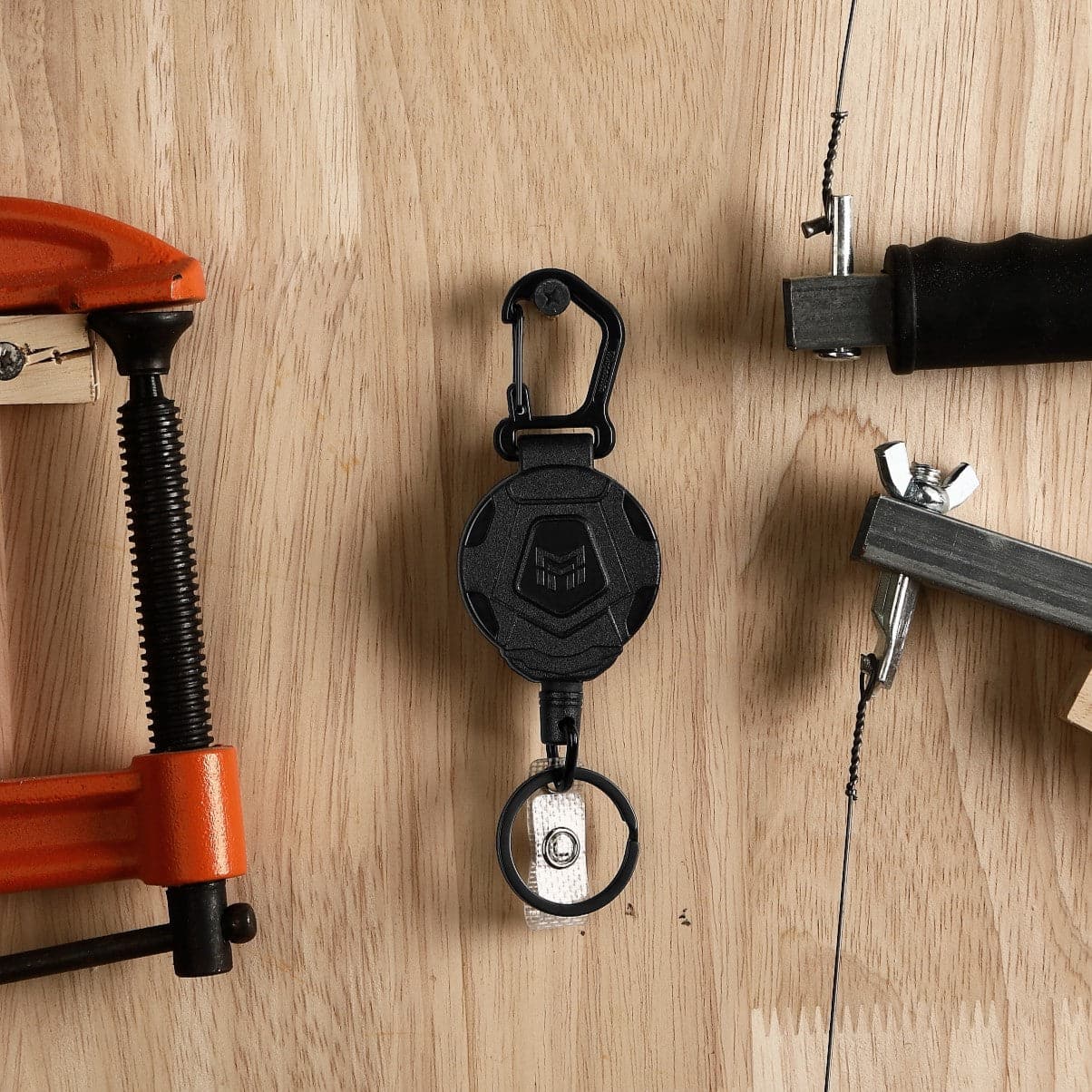 Retractable-Keychain-Carabiner-Holder-Tactical hanging on the tool wall, with saws, hammers etc. usage scenario